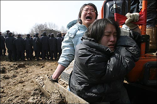 15일 오전 평택 미군기지 확장 예정지에서 논을 파헤치는 포크레인을 붙잡은 여성활동가들이 울부짖고 있다. 